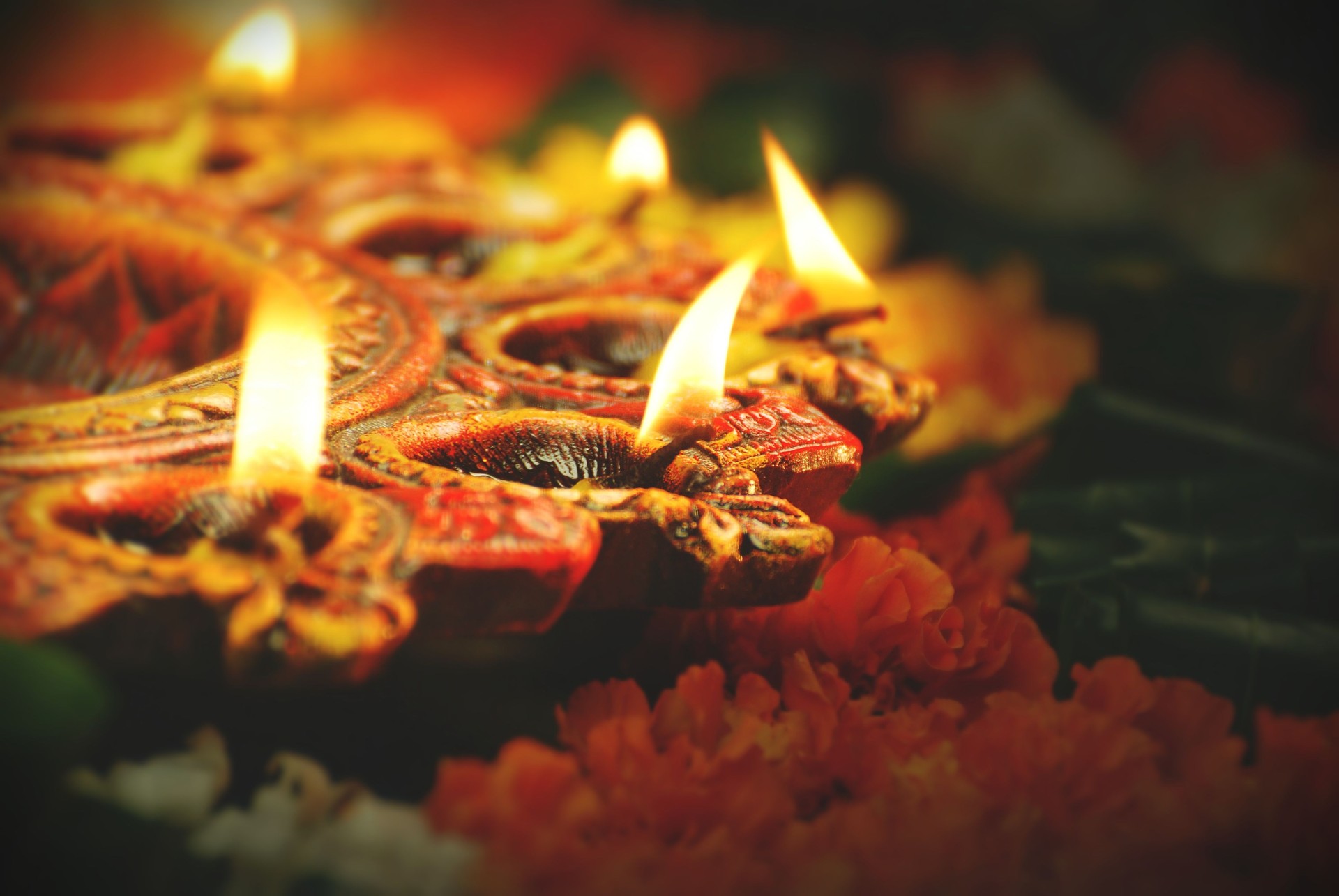 Indian Festival Diwali, Navratri, celebrations vertical picture by lighting colourful Diya Lamps Lights with  marigold flowers and green leaves